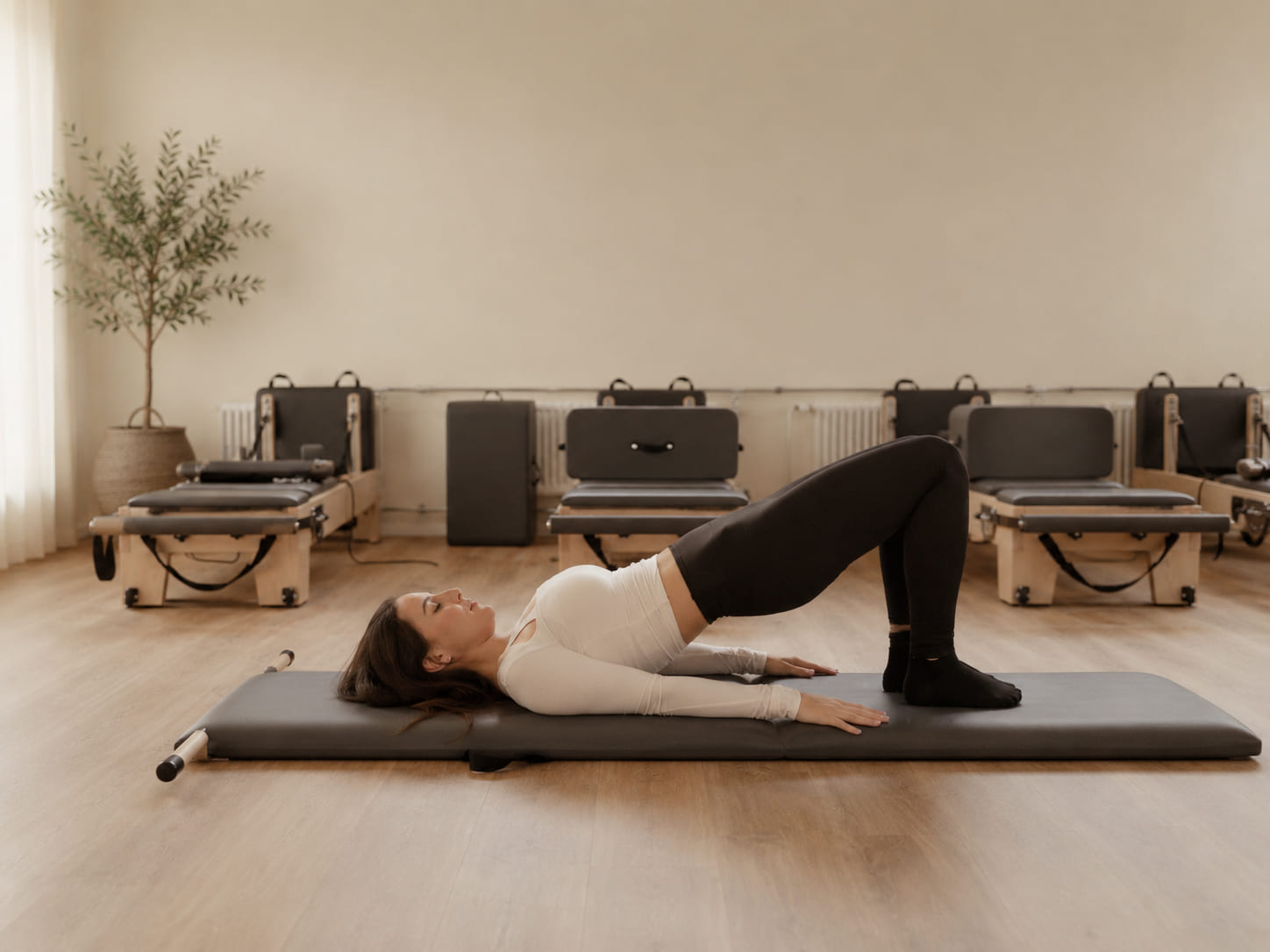 The Élan Pilates studio in Langenthal seen from the doorway, with reformer beds lined up under soft daylight.
