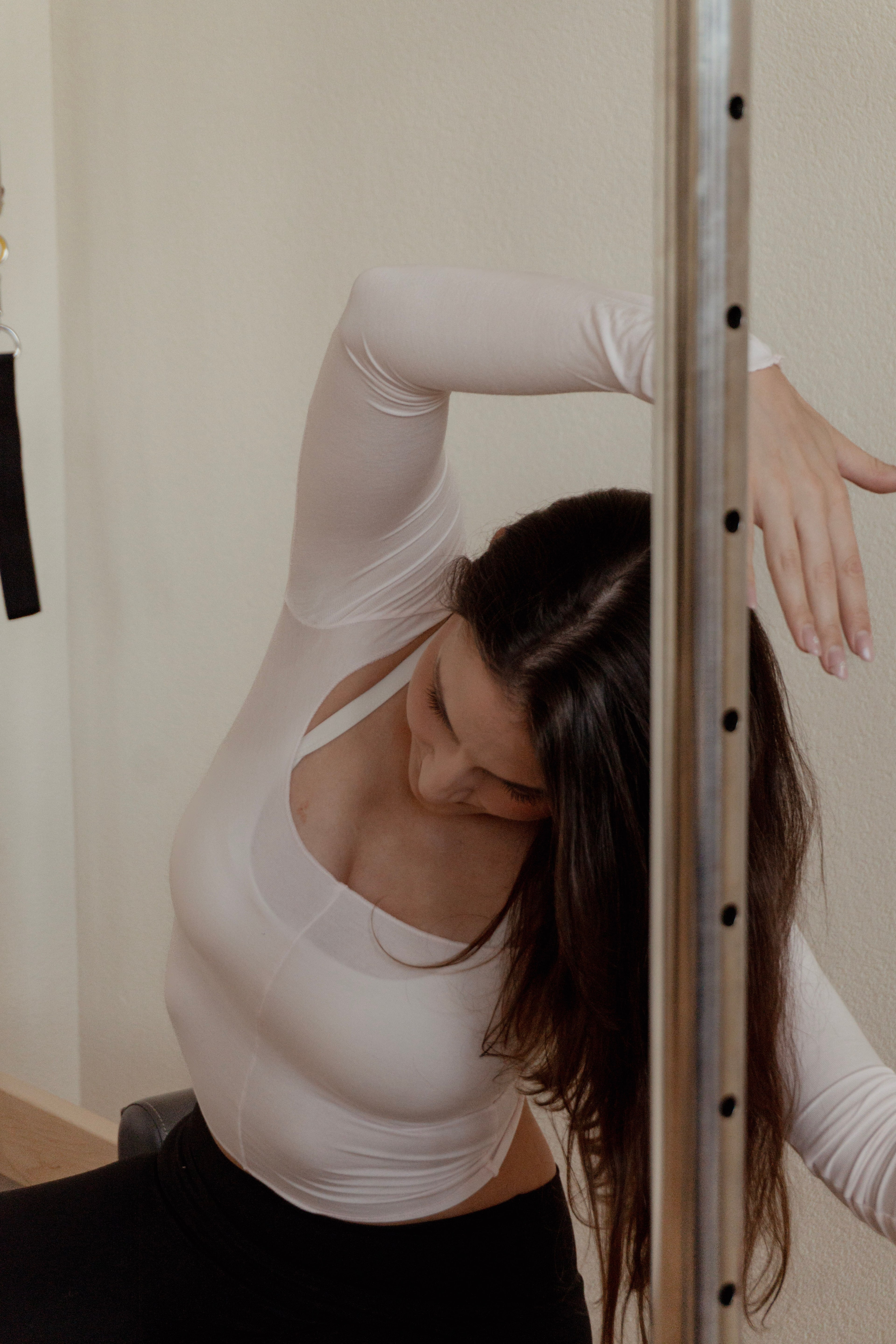 Eine Frau trainiert auf einem Pilates-Reformer im hellen Studio von Élan Pilates in Langenthal.